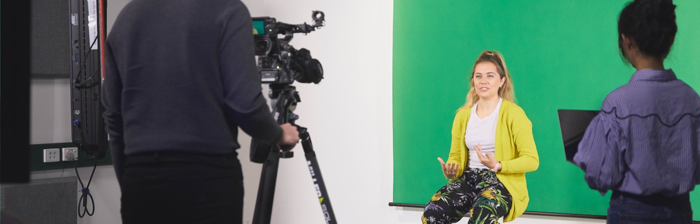 Woman presenting in front of green screen
