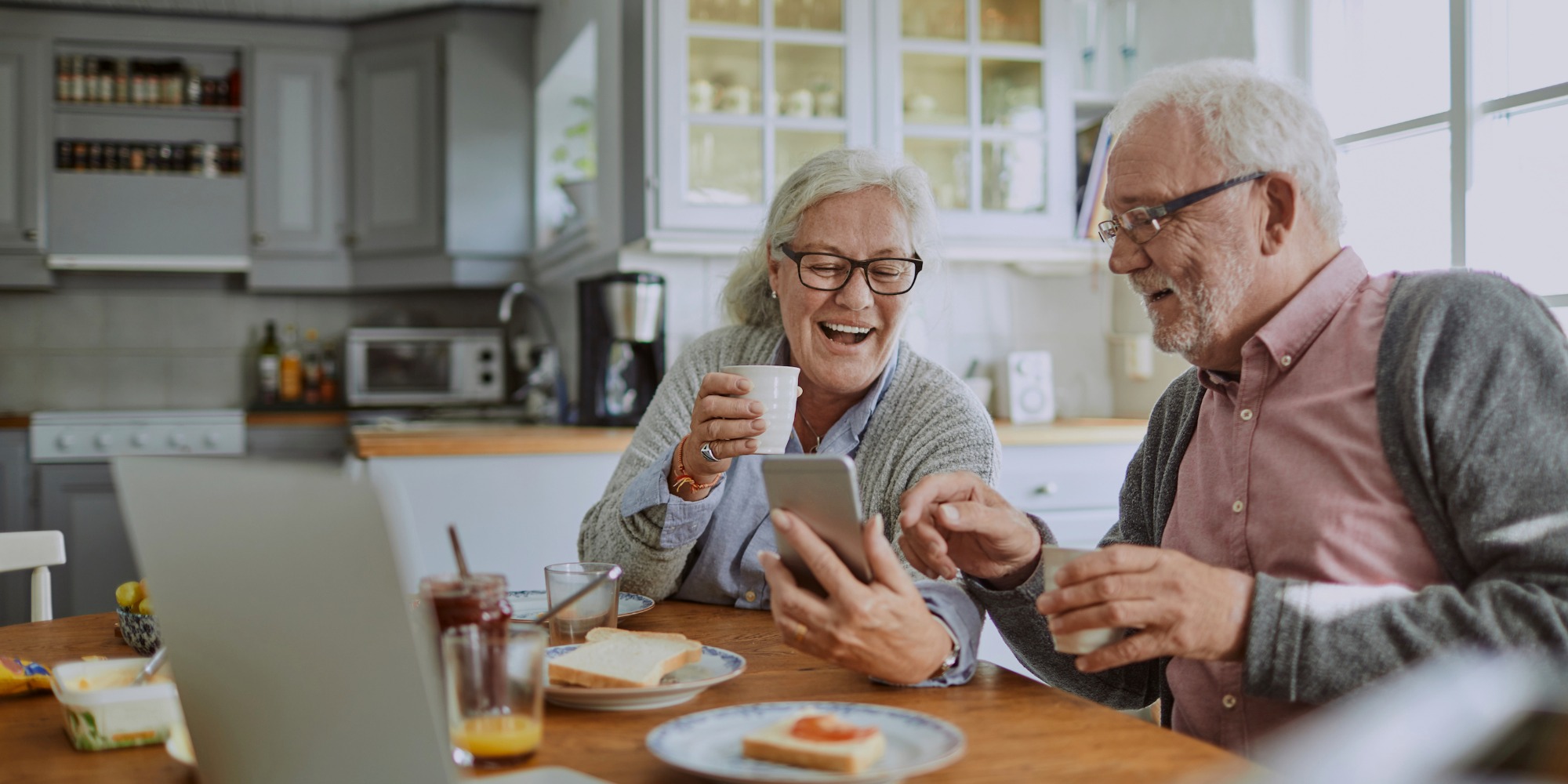 Two old people looking at a smartphone