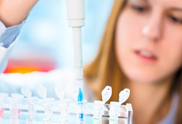 scientist drops blue liquid in vials