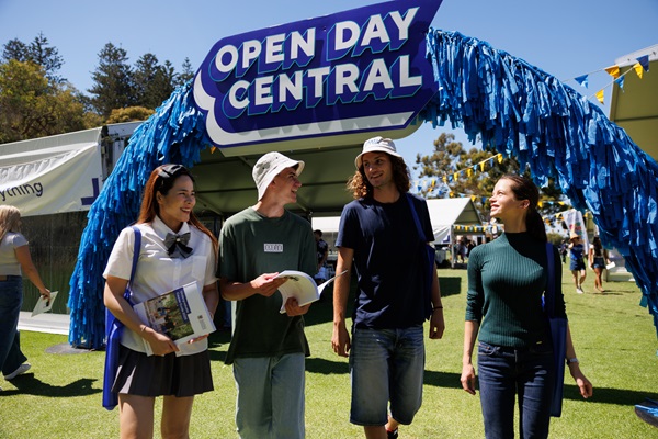 image of four students walking through Open Day Central Hubs on Riley Oval