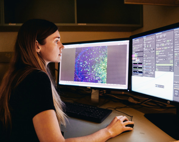 Woman in front of computer monitors
