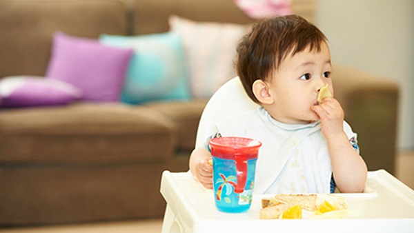 Small child in high chair eating