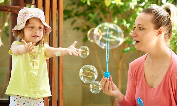 Child and adult blowing bubbles