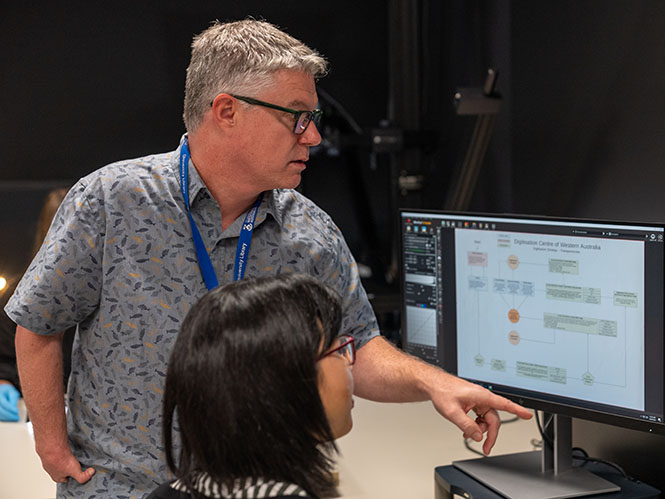Two digitisation staff discussing project planning and flowchart