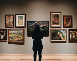 Woman looking at paintings in gallery