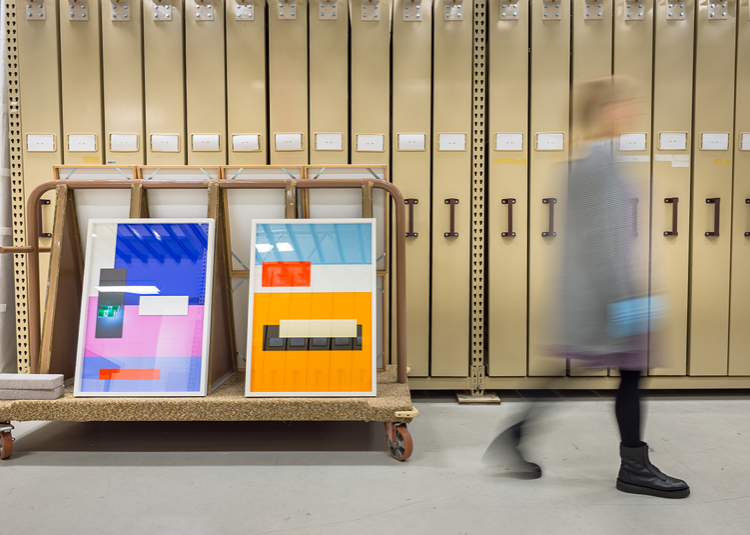 Person walking by archival shelves of museum