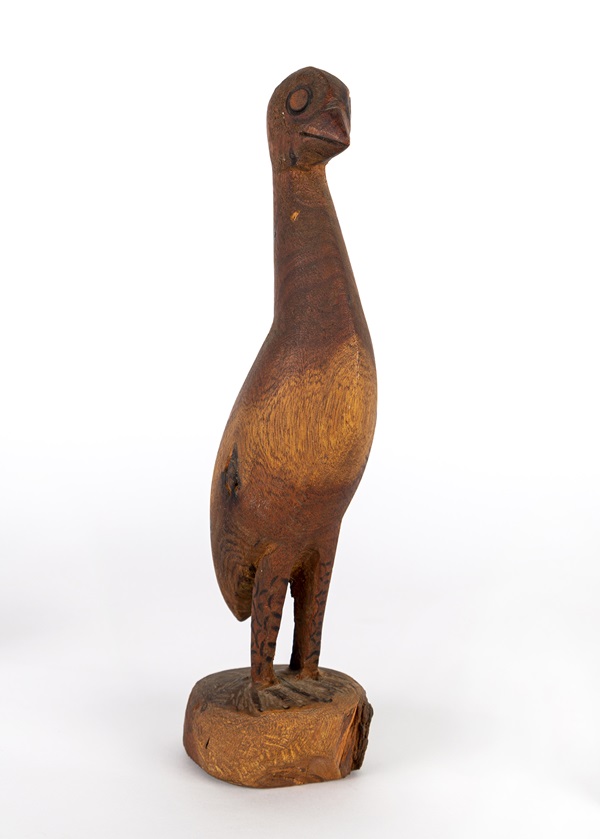 Carved wooden sculpture of an Emu standing on a small, round block of wood