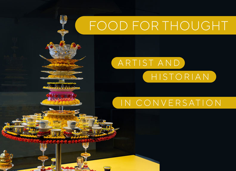 An image of dinner and glass ware stacked and decorated with colourful icing