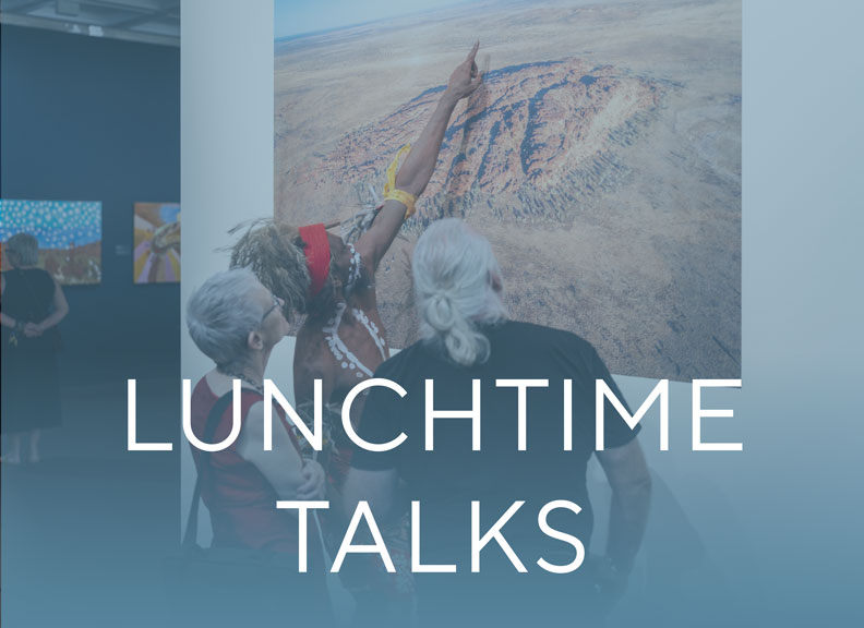 An aboriginal man in traditional ceremonial dress points out something in a photo to two other people. The image includes the text Lunchtime Talks