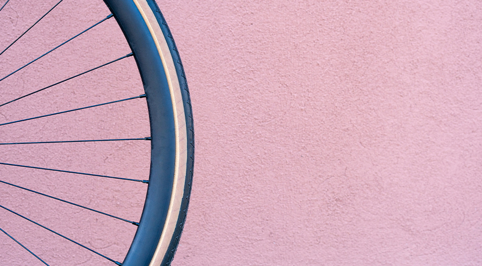 Pink wall and blue bicycle tyre