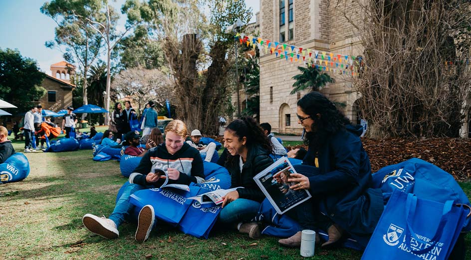 three people smiling sitting outside uwa building