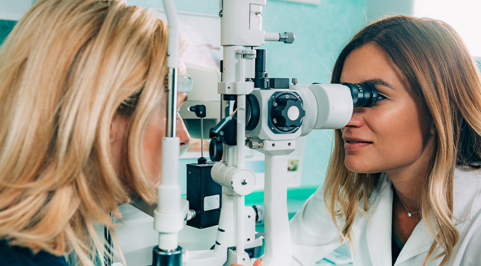 optometrist looking in woman's eye