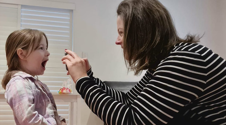 Mother taking a photo of child's teeth