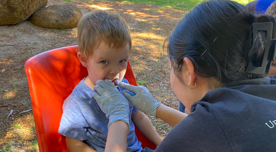 A dental student with a young boy in the Great Southern