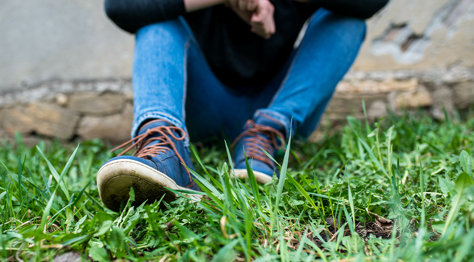 Youth feet sitting in grass