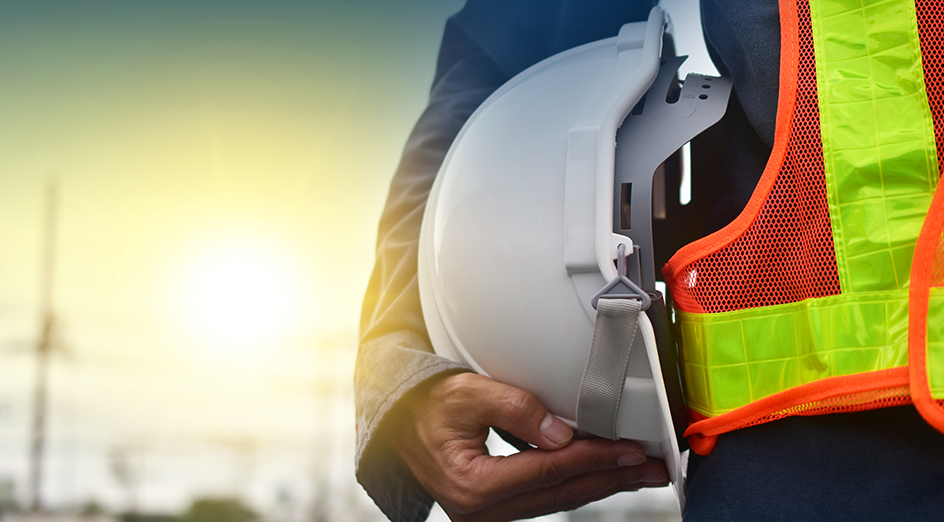 Construction worker holding hat