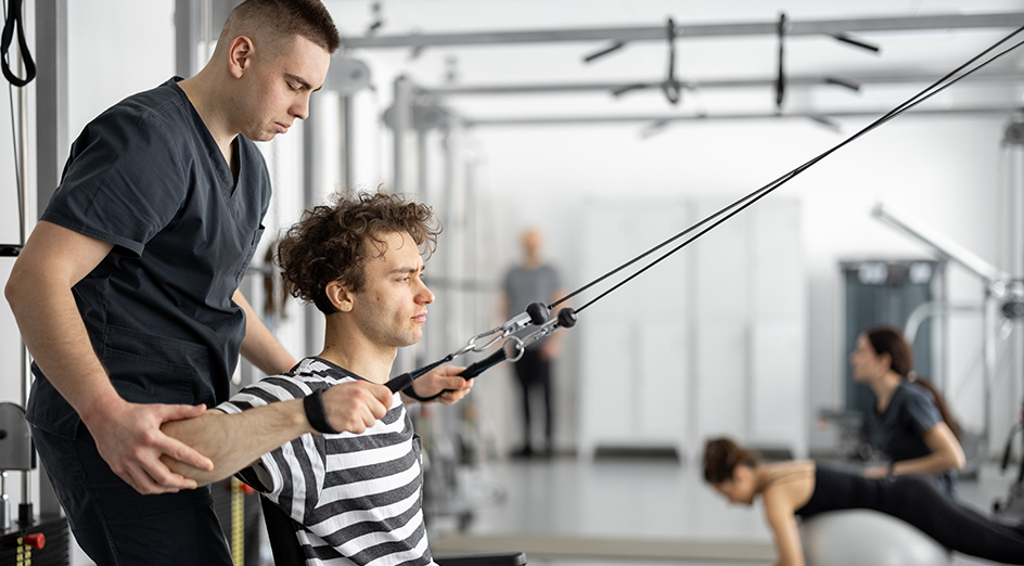 Man assisting patient with exercise