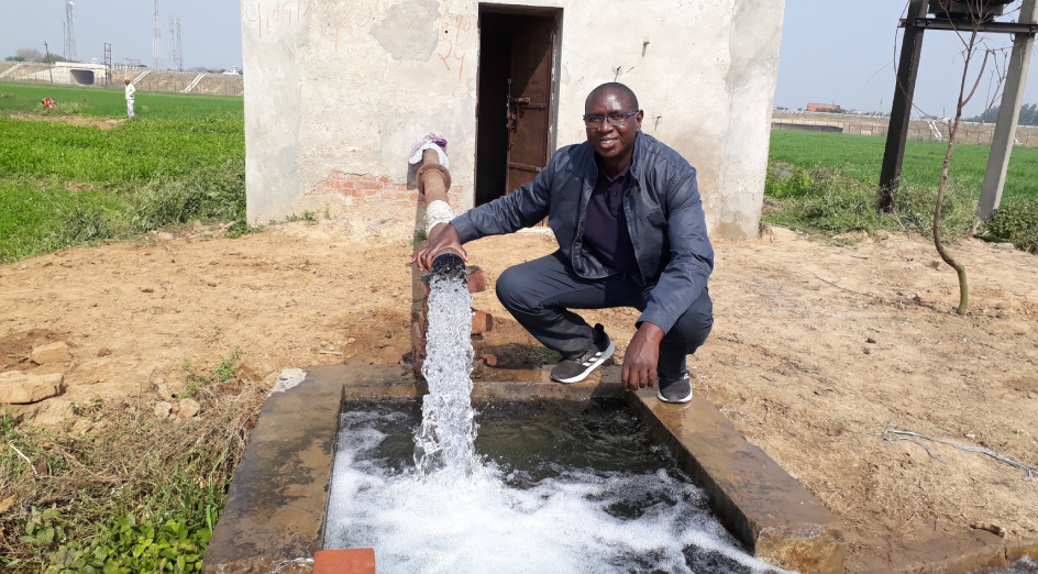 Dr Amin Mugera in Uttar Pradesh, India, pictured with a tube well bringing groundwater to the local community. 