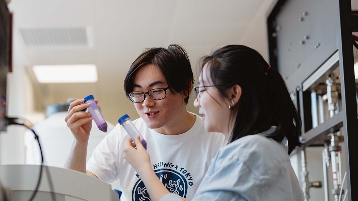 Male and Female student in lab looking at test tubes