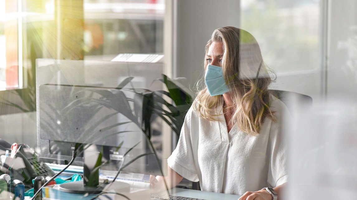 Woman working at desk with mask on