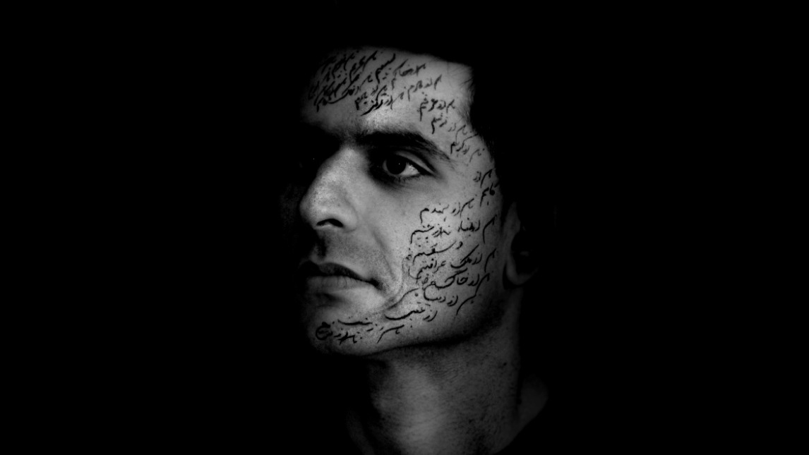 Black and white photo of a face covered in Persian writing