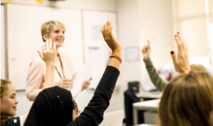 Students raising their hands in classroom
