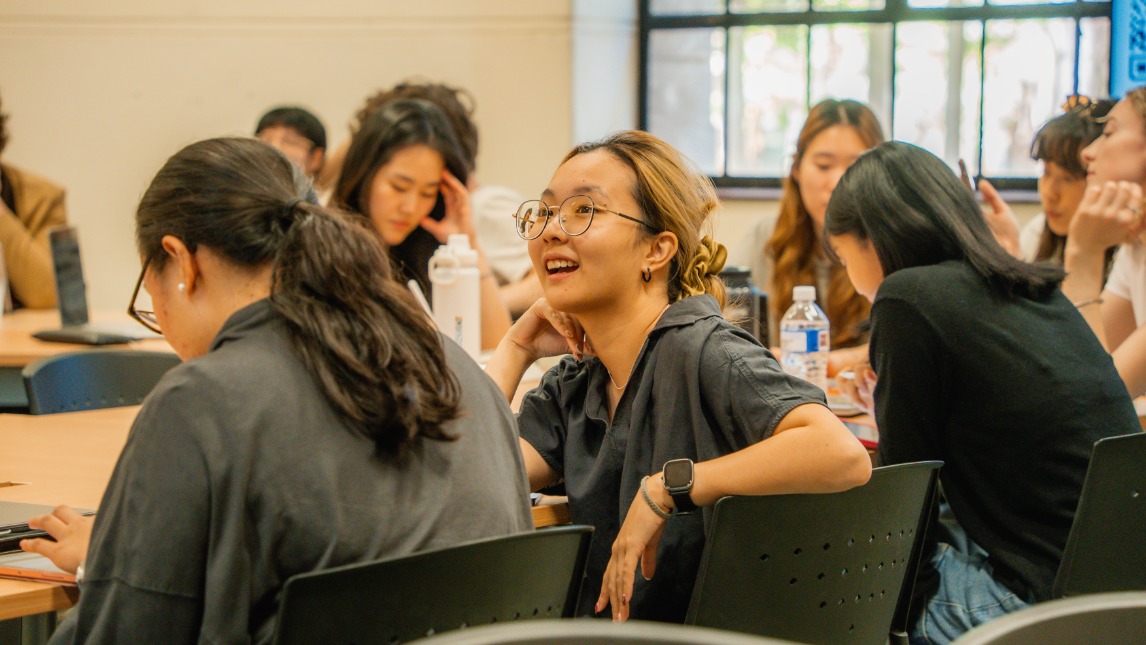 Students in a classroom with one looking up and smiling