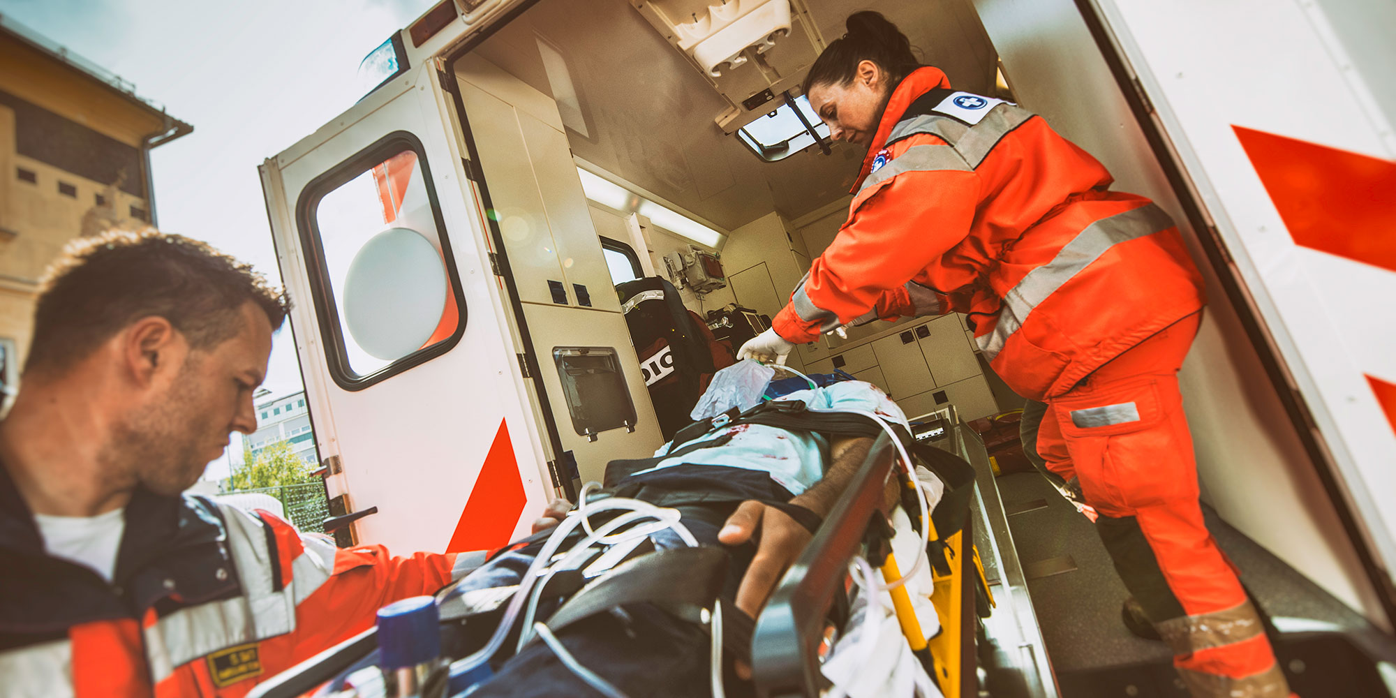 image of paramedics loading a patient into an ambulance