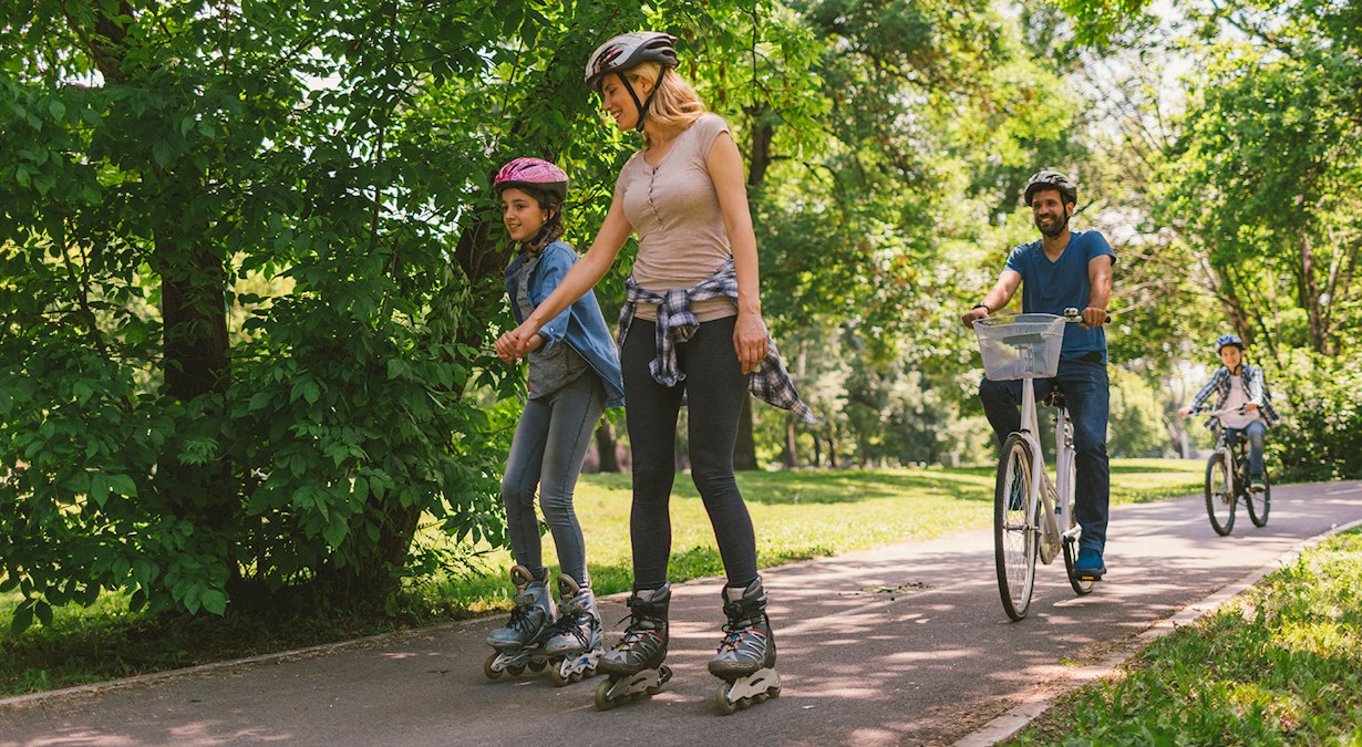 family rollerblading in a park