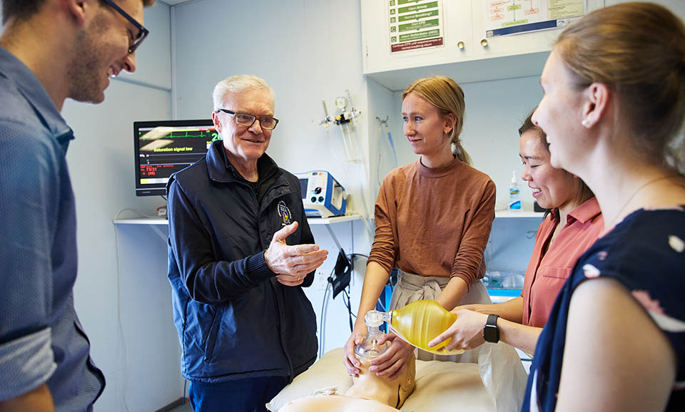 medical supervisor leading students in a procedure utilising a medical mannequin