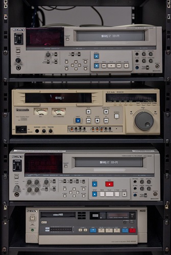 Various VHS and video Hi8 players on a shelf