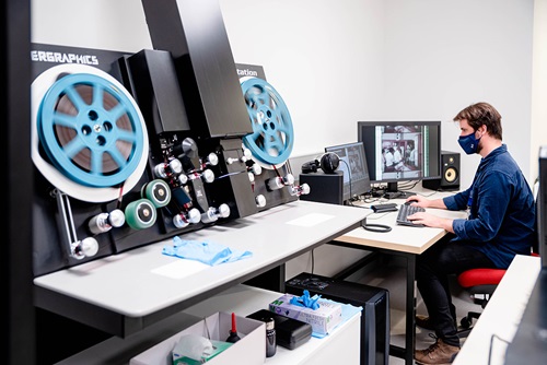 A male digitisation officer scanning film reels using Lasergraphics ScanStation 6.5K setup