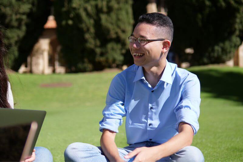 Calvin Lee sitting on campus living the international student dream