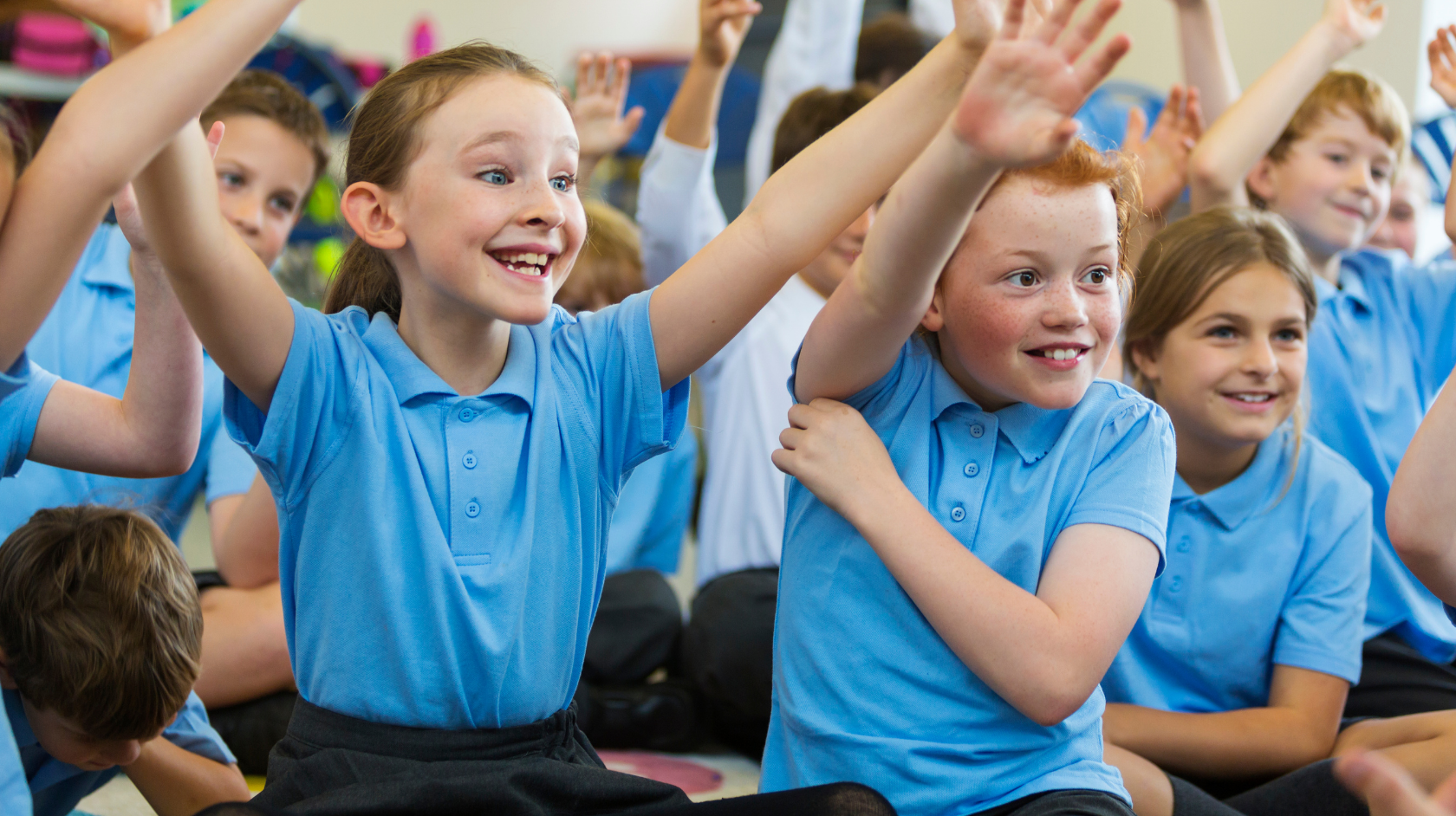 Primary school children raising hands