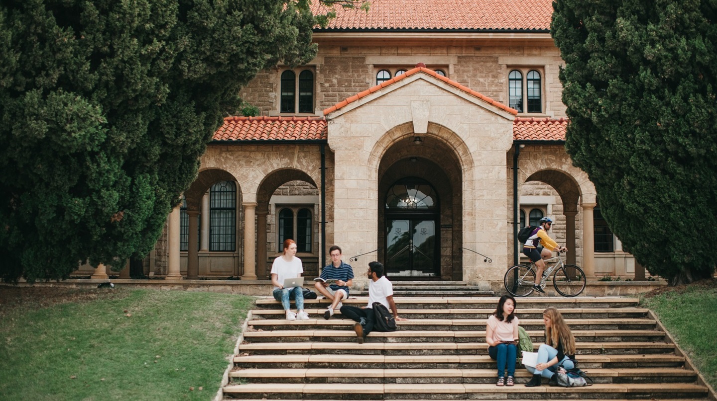 Students sitting outside on steps on UWA campus