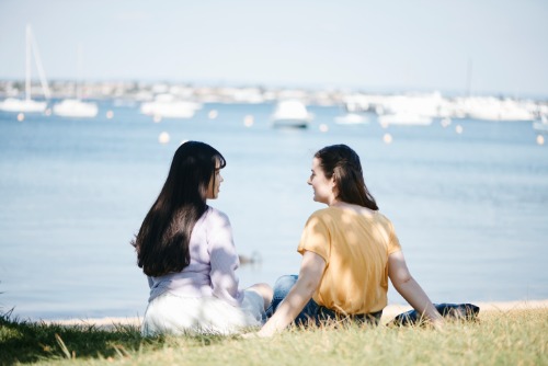 Two people sitting outdoors by the river