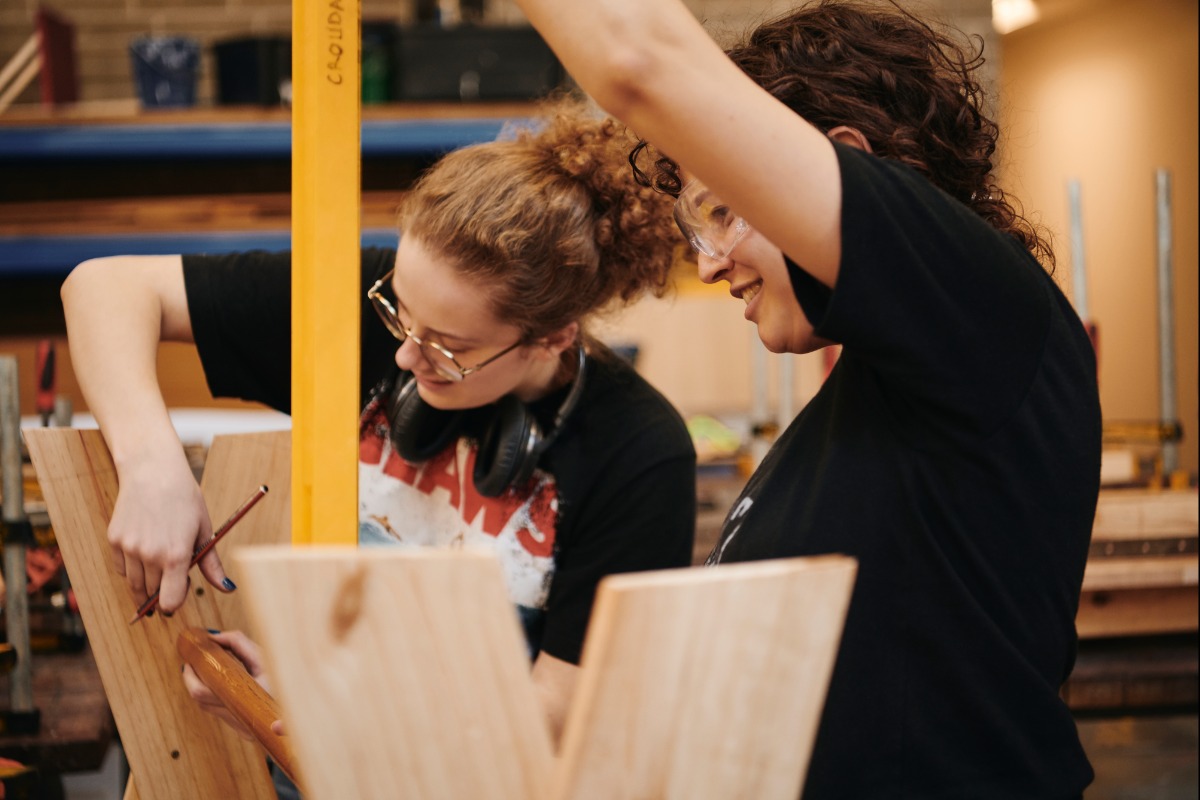 Two students creating a wooden object in the UWA School of Design workshop