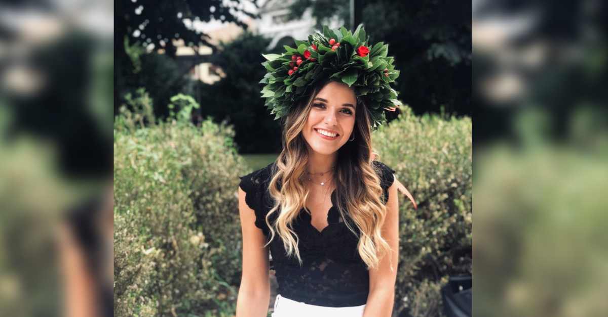 Picture of UWA student Nicole wearing a crown made of leaves and standing in front of a garden.