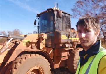 Corey in front of mining machinery