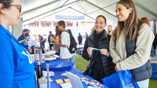 Parent and teenager chatting to UWA Staff member at Open Day