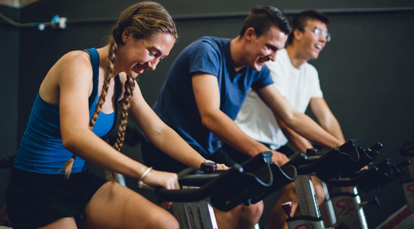 Students exercise on spin bikes