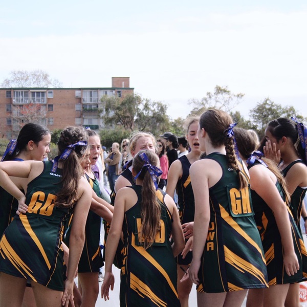 UWA Netball Club players stand in a huddle