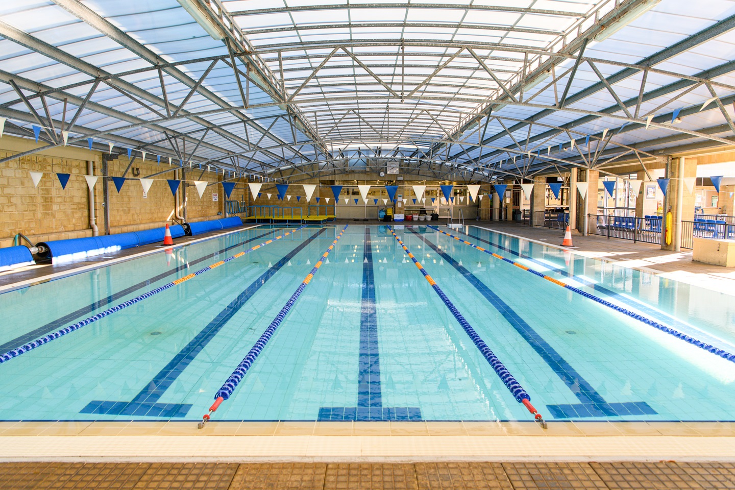 A photo of an undercover 5-lane pool with lane ropes, 25m in length,
