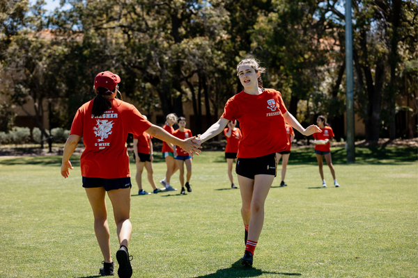 Two St. George's students share a high-five in passing on James Oval