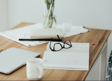 Book open on a table with a pair of glasses
