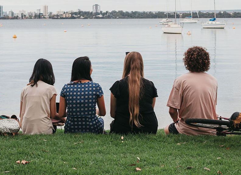 Students sitting on river bank