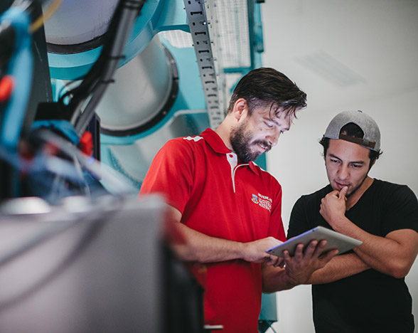 Student and teacher usign ipad in front of machine