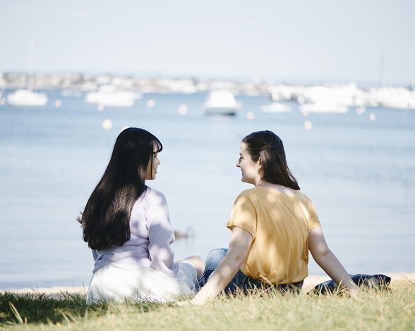 Two students  sitting on river bank