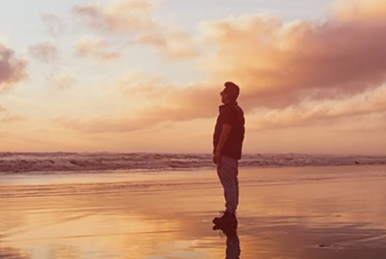 A person watching a sunset on the beach