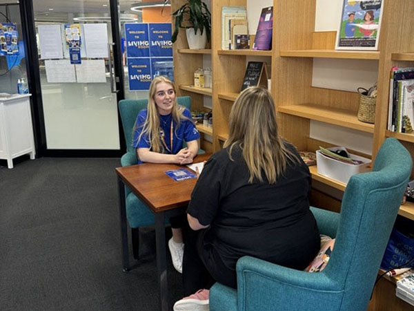 Trained peer supporter seated in conversation with a student